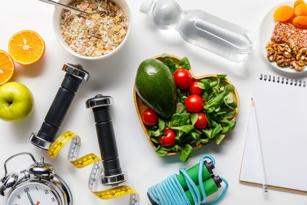 Frukt og grønt, samt vann, målebånd og vekter på et bord